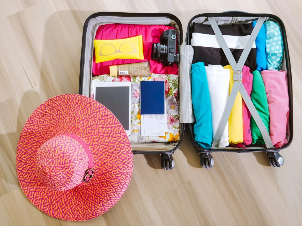 Open suitcase with clothes and travel essentials for a warm-weather trip