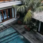 Illustrative tropical villa and swimming pool surrounded by greenery
