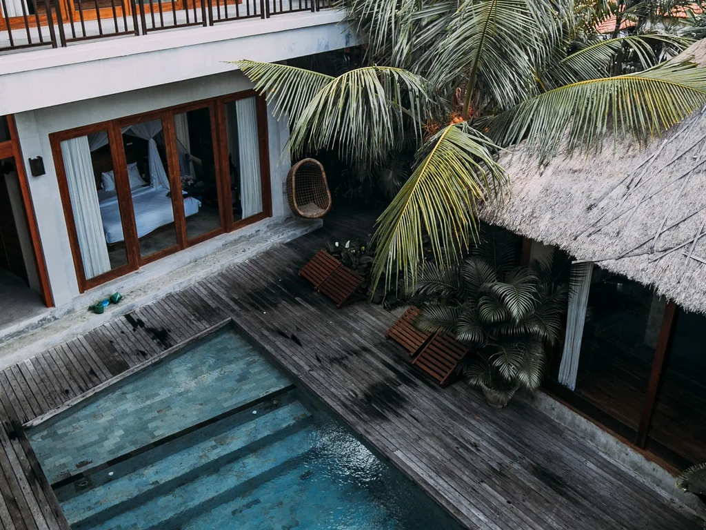 Illustrative tropical villa and swimming pool surrounded by greenery